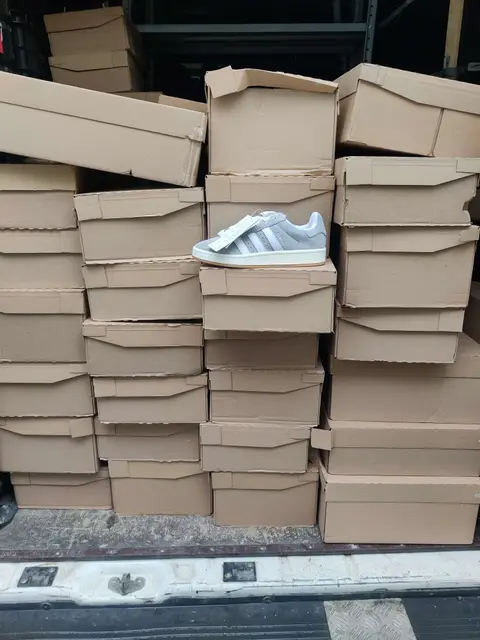 A van loaded with shoe boxes, a pair of Campus on top