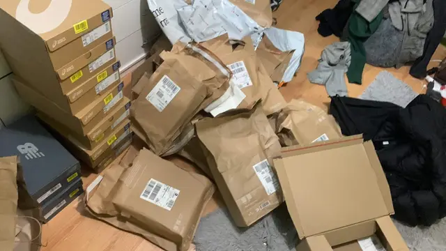 Opened parcels and shoe boxes across a bedroom floor
