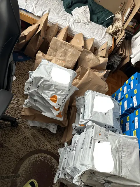 Parcels and Adidas boxes filling a bedroom