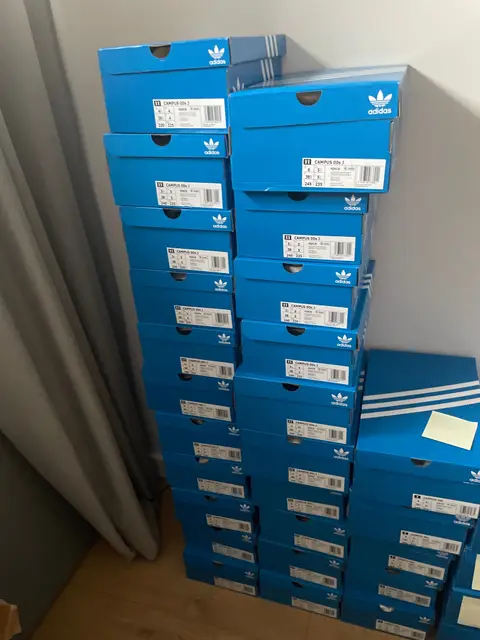 A tall stack of Adidas boxes in a corner